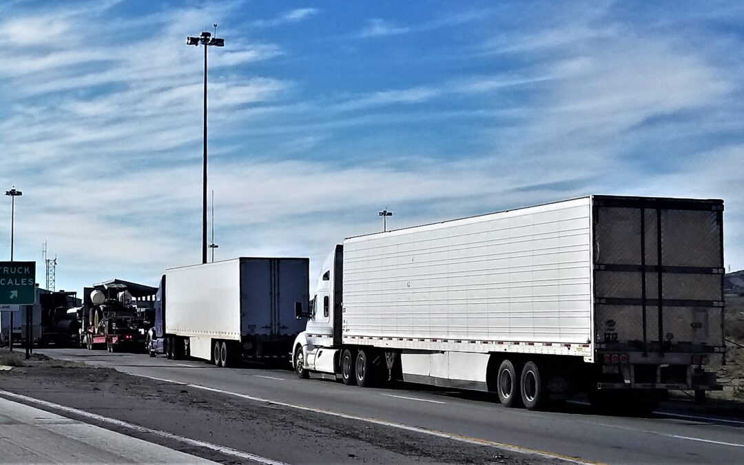 Two Trucks at a weigh station off an exit.